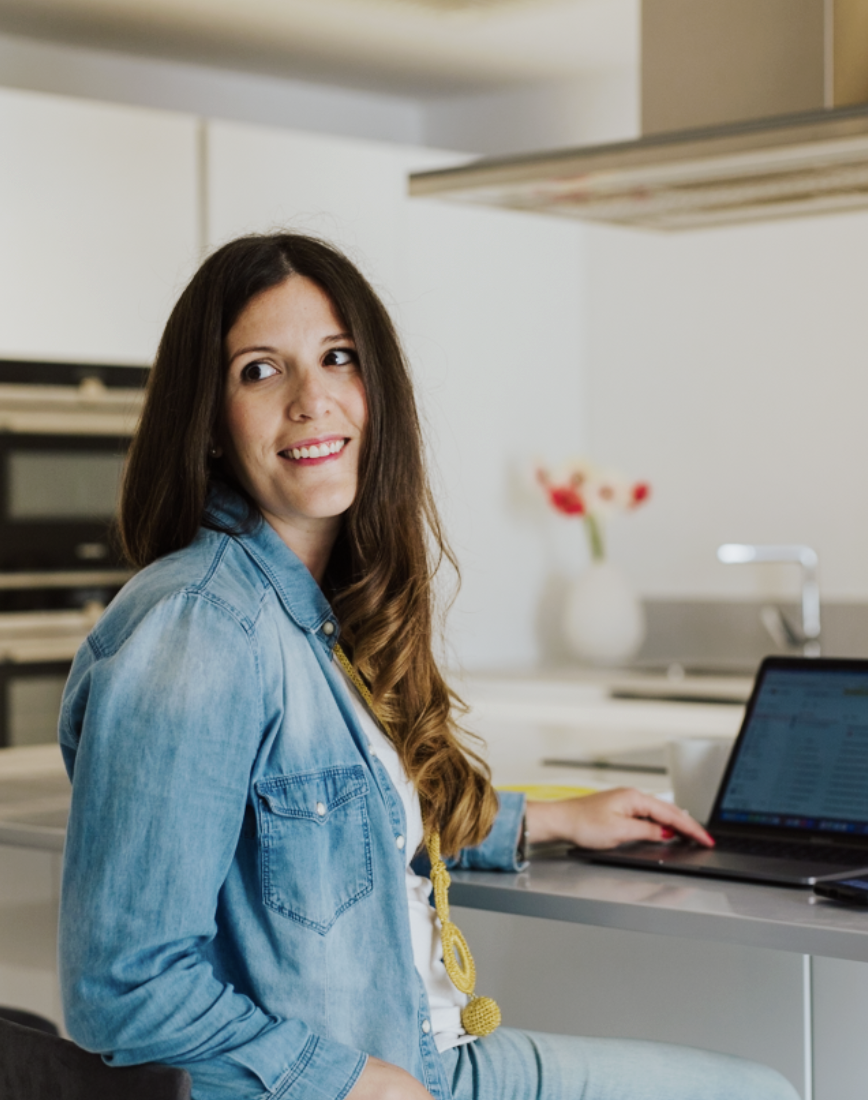 Becky working on a laptop at a kitchen counter